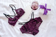Gift, shopping and fashion concept. Set of glamorous stylish sexy lace lingerie on bed with giftbox and wineglass on white background. Woman accessories.