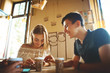 © vitaliymateha - couple sitting at cafe table, talking and smiling. Young people meeting in a cafe.