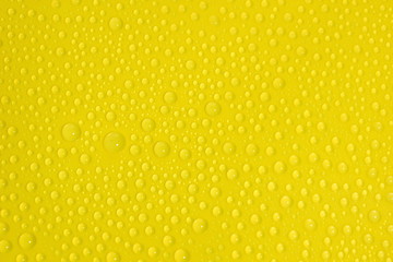 Wall Mural - natural water drops on yellow background texture