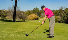 Man Teeing Off On A Golf Course