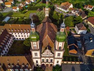 Wall Mural - Soaring majestic church Saint Maurice in little french village Ebersmunster. Aerial drone view.