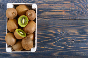 Wall Mural - Fresh ripe kiwi fruit in a wooden box on the table. Tropical Fruit. Healthy food.