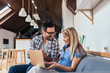 © bnenin - Young couple surfing on internet with laptop in modern apartment.