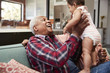 © Monkey Business - Grandparents Sitting On Sofa Playing With Baby Granddaughter At Home