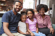 © Monkey Business - Portrait Of Family Relaxing On Sofa At Home Together