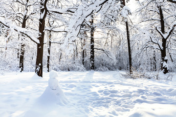 Sticker - snowman on snow-covered meadow in oak grove