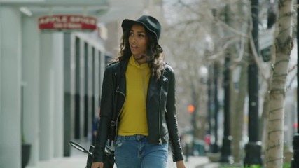 woman walking on city sidewalk and looking around / salt lake city, utah, united states