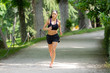 © SB Arts Media - young pretty runner working out in a green city park in exercise fitness concept