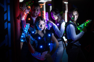 Young people with laser guns on lasertag arena