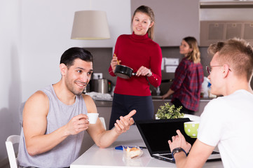 Poster - Man talking to guy in kitchen of hostel