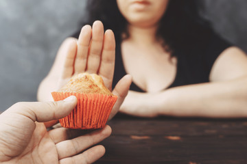 Wall Mural - Sugar addiction, healthy lifestyle, weight loss, dietary, healthcare and medical concept. Cropped portrait of overweight woman refusing muffin
