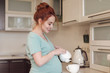 © diignat - Smiling pregnant woman pouring tea