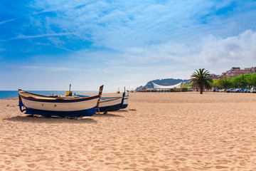 Wall Mural - Beach at seaside in Calella in Catalonia, Spain near Barcelona. Scenic old town with sand beach and clear blue water. Famous tourist destination in Costa Brava, perfect place for holiday and vacation