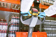© Seventyfour - Crop sports nutrition production worker hands in protective gloves pushing stacker truck handle in warehouse.