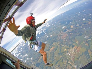 Brave Parachutist with red helmet jump out of the plane