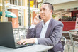 © thampapon1 - Asian Businessman use Wireless Digital Smartphone and Laptop or Notebook Computer