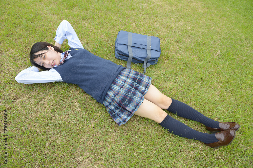 芝生に寝転がる女子高生 の Stock フォト | Adobe Stock