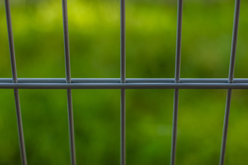 soft focus metal fence on green background concept with empty space for copy or text