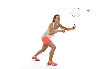 Wall Mural - Young woman playing badminton over white background