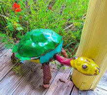 Colorful Sculpture Of Turtle On Wooden Floor Near Green Grass. 
Recycled Scrap Metal Yard Art. Beautiful Garden Decor Object. Summer View Outdoors. 