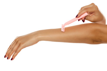 Woman shaves her arm on white background