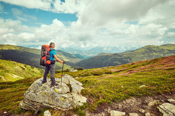 Wall Mural - Man with red backpack enjoying landscape on cliff solo traveling healthy lifestyle concept active summer vacations