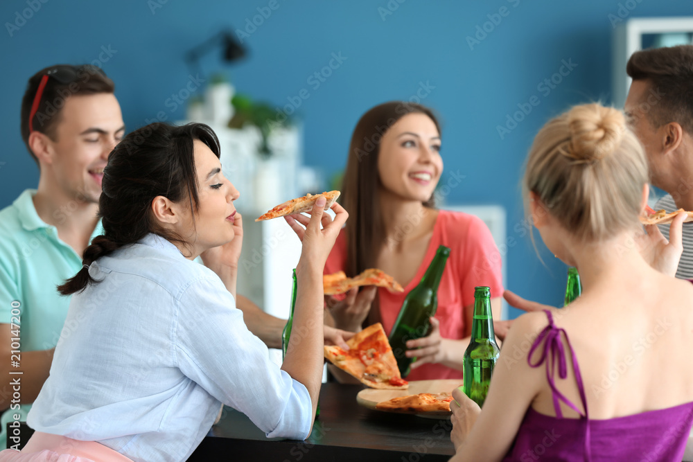 Young people having fun at party with delicious pizza indoors