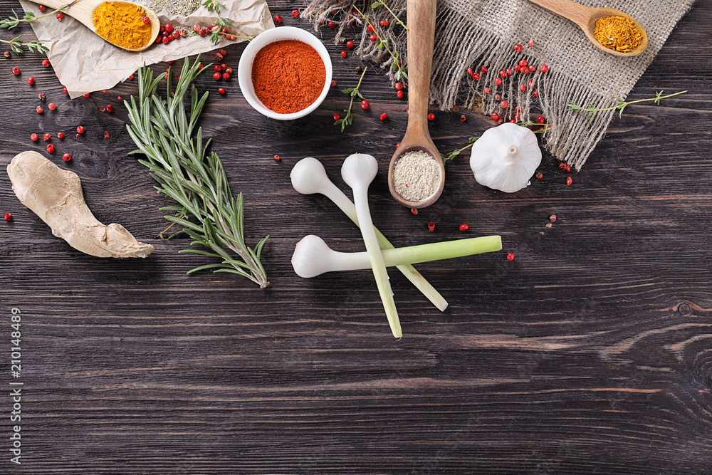 Various spices with herbs on wooden background