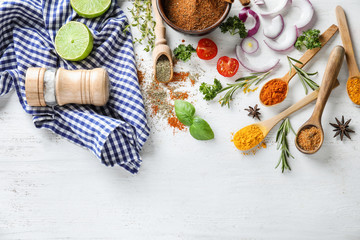  Various spices with herbs and vegetables on wooden background