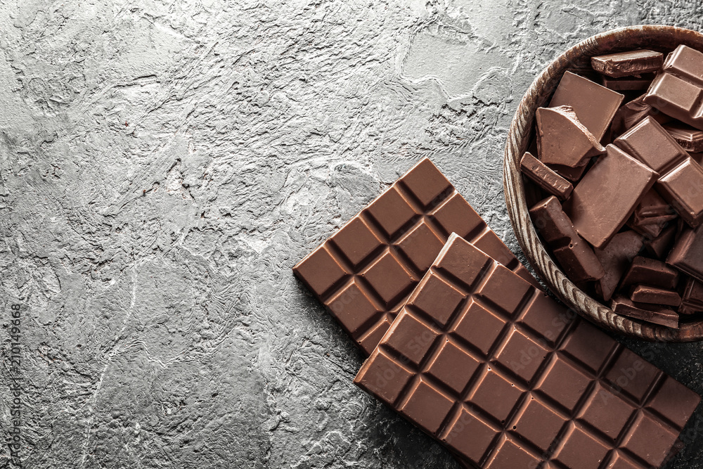 Composition with tasty milk chocolate on grey textured background