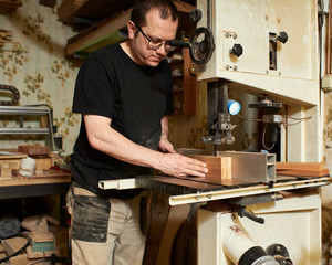 Sawing the board for the subsequent production of the head and heel of the classical guitar.