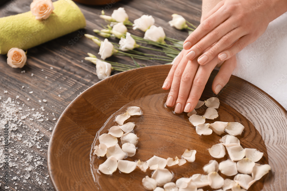 Young woman undergoing spa manicure treatment in beauty salon