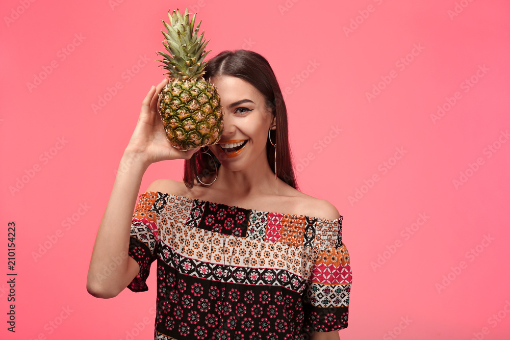 Attractive young woman with pineapple on color background