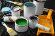 © Pixel-Shot - Cans of paint, roller and brush on plastic cover