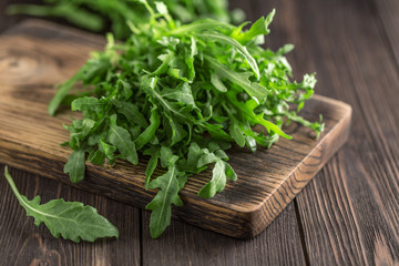 Fresh green arugula in bowl on table. Arugula rucola for salad. Close up of fresh green healthy food. Diet concept.