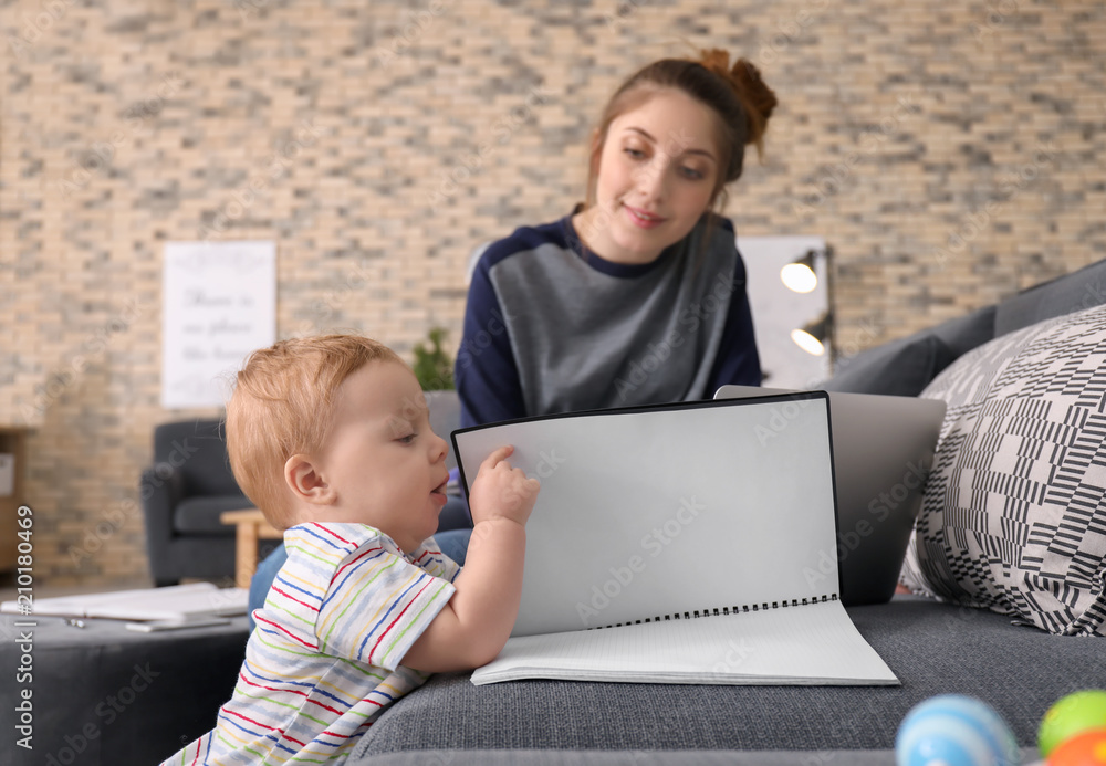 Young mother with baby working at home