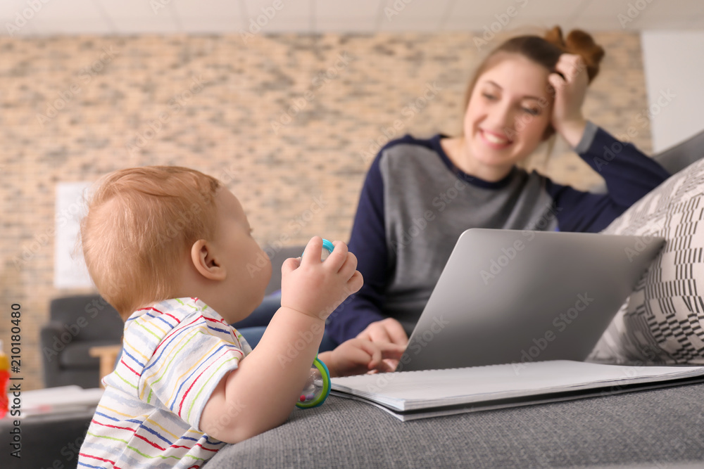 Young mother with baby working at home