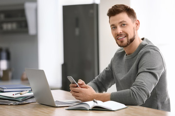 Freelancer with laptop and mobile phone at home