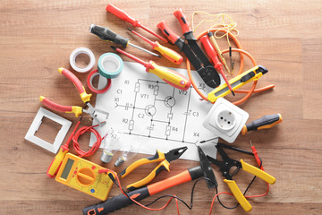 Wall Mural - Electrician's supplies and circuit diagram on wooden background