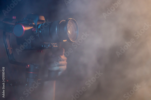 object for smooth video production to make movie . camera stability automatic system , electric machine . professional film maker with gimbal . closeup abstract smoke scene background .