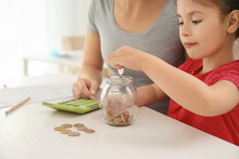 Little Girl With Her Mother Sitting At Table And Counting Money Indoors. Money Savings Concept
