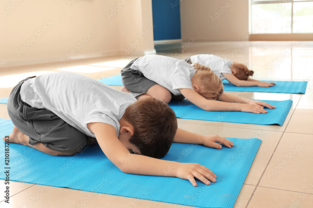 Little children practicing yoga indoors