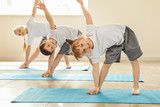 Little children practicing yoga indoors