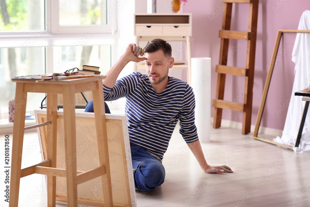 Male artist waiting for inspiration in workshop