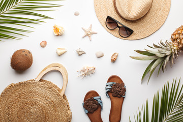 Summer composition. Fruits, hat, tropical palm leaves, seashells on white background. Flat lay, top view, copy space.