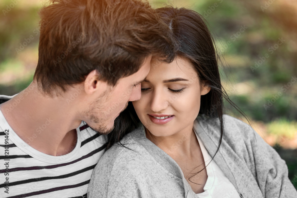 Happy young couple resting in green park