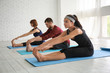 © Pixel-Shot - Group of sporty people practicing yoga indoors