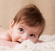 Portrait of an adorable curious little boy lying on his stomach