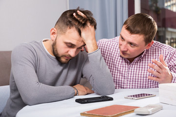 Wall Mural - Friend calming distressed guy at home table