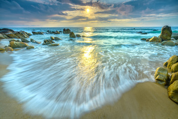 Dawn on beautiful beaches with white sand streaks waves like silk to create many beautiful shapes on the beach has many rocks,